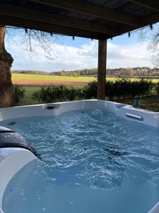 a jacuzzi tub with a view of a field at Moonshine in Grimston