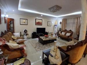 ein großes Wohnzimmer mit Sofas und Fernseher in der Unterkunft Appartement Villa Saran, Nongo in Conakry