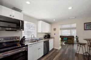 フォートマイヤーズビーチにあるTan Lines by Sun Palace Vacationsのシンクとコンロのあるキッチン トップオーブン