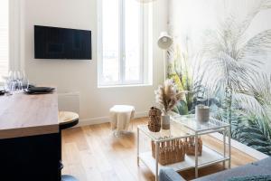 a living room with a table and a living room with a couch at Petit appartement pour 2 à 3 personnes in Caen