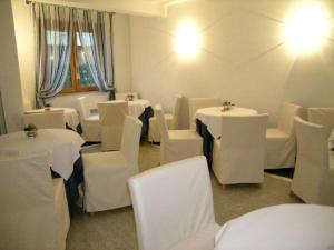 a dining room with white tables and white chairs at Meubleterme in Grado