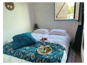 a bed with a bowl of flowers on top of it at Appartement Piscine privée in Saint-Cyprien-Plage