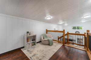 a living room with a chair and a staircase at Pine Cone Cottage in Hamptonville