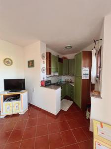 eine Küche mit grünen Schränken und roten Fliesenböden in der Unterkunft Casa Terrazza sul Golfo in Cannigione