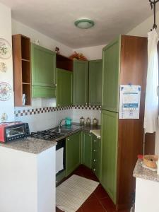 a green kitchen with green cabinets and a sink at Casa Terrazza sul Golfo in Cannigione +13 photos