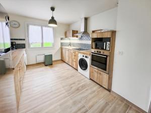 a kitchen with a washer and dryer in it at Villa L'Isachrist, Calme, Confort, 20' Disneyland in Maisoncelles-en-Brie