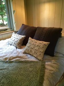 uma cama com almofadas em frente a uma janela em Chez Marguerite Luxury Shepherd's Hut em Holt