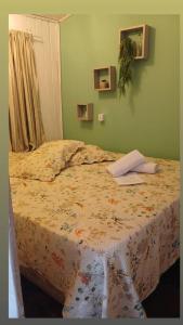 a bedroom with a bed with a flowered bedspread at Casa da Vovó in Camboriú