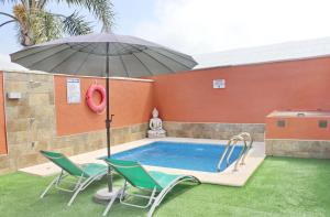 basen z dwoma krzesłami i parasolem w obiekcie Chalet Sultan con piscina w mieście Conil de la Frontera