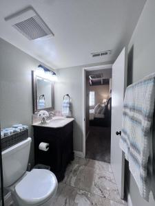 une salle de bain avec un lavabo, des toilettes et un miroir dans l'établissement Destination #20, à Anaheim