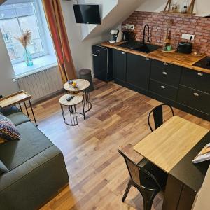 a kitchen and living room with a couch and a table at GÎTE L'industriel, appartement privé en Duplex, à 10 minutes des plages in Lanhouarneau +12 photos
