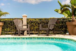 two chairs sitting next to a swimming pool at Villa Horizon Bleu - Vue Mer & Piscine Chauffée in Le Tampon