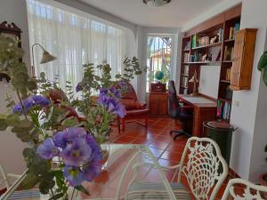 a living room with a glass table and purple flowers at Villa con piscina junto a la playa in Roche