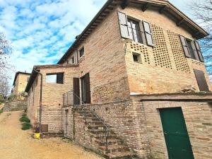 an old brick building with a green door and stairs at Da Taz Siena in Siena
