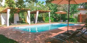 basen z leżakami i parasolami na dziedzińcu w obiekcie El Manantial Del Fresno Casas Rurales En Hervás - Piscina - Desayunos - Barbacoa - Parking gratis w mieście Hervás