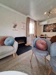 a living room with two chairs and a fireplace at Stelle Maris Wellness, carefree enjoyment! Private Sauna & Hottub in Zeeland, Airco, Free Wifi and more! in Heinkensand +54 photos