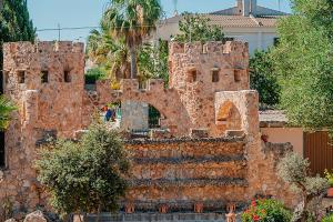 ein aus Ziegelsteinen errichtetes Gebäude vor einem Haus in der Unterkunft Castell Villa Bohío Mallorca in Urbanicacion ses palmeres