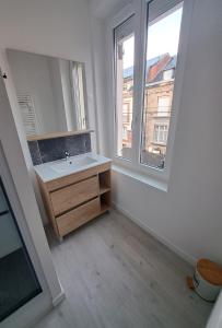 um banheiro com pia e janela em Gite Ardennais 18 personnes "les gronchons" em Haybes