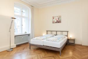 a white bedroom with a bed and a window at GreatStay Apartment - Bornstedterstr. in Berlin
