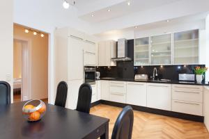 a kitchen with white cabinets and a table and chairs at GreatStay Apartment - Bornstedterstr. in Berlin