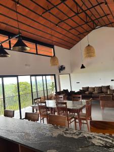 ein Wohnzimmer mit Tischen und Stühlen und einer Couch in der Unterkunft Sylvan Retreat - Luxury Mountain Cottages in Vagamon