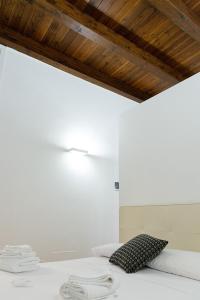 1 dormitorio con 1 cama con almohada blanca y negra en Graffiti Living Niglio, en Corato