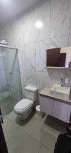 a white bathroom with a toilet and a sink at stone house in Balneário Gaivotas