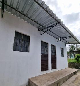 awning on the side of a white house at Apartamento em Presidente Figueiredo in Presidente Figueiredo