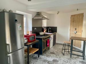 a kitchen with a stainless steel refrigerator and a stove at Gite Les Bluettes in Bracieux