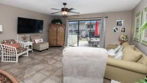Una sala de estar con un sofá y un televisor de pantalla plana. en 2 BD 2 and half BA Two Story Beach Haven Pet Friendly with Golf Cart, en Panama City Beach