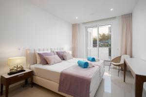 ein weißes Schlafzimmer mit einem großen Bett und einem Fenster in der Unterkunft Ancora Apt do Mos in Lagos + 14 Fotos