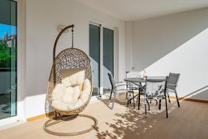 ein Schaukelstuhl in einem Wohnzimmer mit einem Tisch in der Unterkunft Ancora Apt do Mos in Lagos