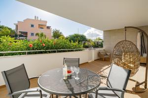 ein Glastisch und Stühle auf einem Balkon in der Unterkunft Ancora Apt do Mos in Lagos