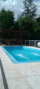 a blue swimming pool with a gazebo at Ollagua casa con pileta Villa Ventana in Villa Ventana +2 photos