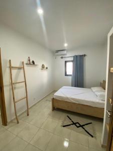 Un dormitorio con una cama y una escalera dentro. en Résidence Attika, en Cap Skirring