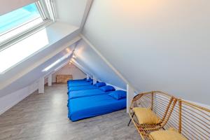a room with a blue bed in the attic at Ker Breizh - Saint Pabu - 14 pers in Saint-Pabu