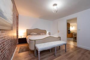a bedroom with a bed with a bench in it at Petit appartement in Saint-Gildas-de-Rhuys