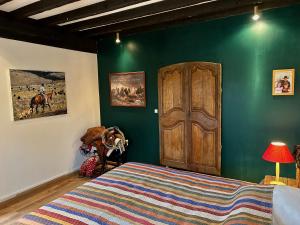 a bedroom with a bed and a green wall at La Forge Tranquille in Heudreville-sur-Eure +5 photos