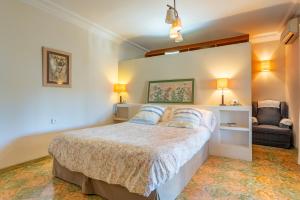 ein Schlafzimmer mit einem großen Bett und einem Stuhl in der Unterkunft Binibonaire in Binissalem