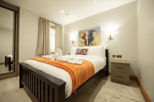 een slaapkamer met een groot bed en een oranje deken bij Oak Lodge in Reading