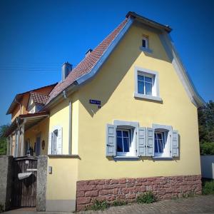 a yellow house with a red roof at Ferienwohnung La Maison Palatinate in Kapsweyer