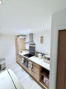 a kitchen with wooden cabinets and a stove at Cozy bungalow near Peak District in Stockport