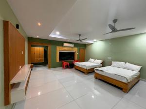 a living room with two beds and a tv at Yanam resorts in Yanam +34 photos