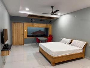 a bedroom with a bed and a table and a television at Yanam resorts in Yanam