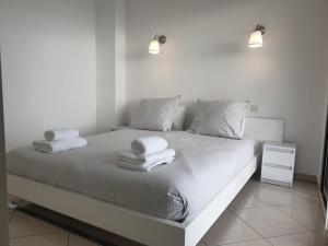 a bedroom with a white bed with towels on it at Les Jardins de Monaco in Cap d'Ail