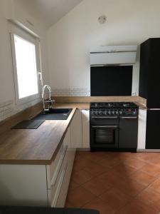 une cuisine avec un évier et une cuisinière dans l'établissement Villa Bord de Mer Piscine, à Plouha