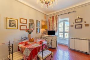 een eetkamer met een tafel en een televisie bij Appart face au Palais des Papes in Avignon