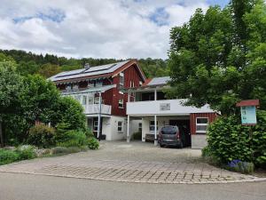 dom z samochodem zaparkowanym przed nim w obiekcie Ferienwohnungen Kätzlehaus w mieście Meßstetten