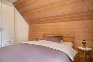 a bedroom with a bed with a wooden wall at Casa Orazio Haus In Bregenz in Bregenz +21 photos