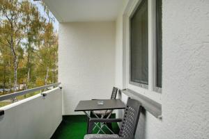a table and chairs on a balcony with a window at Modern Apartments Neuburg 2 - New in Neuburg an der Donau